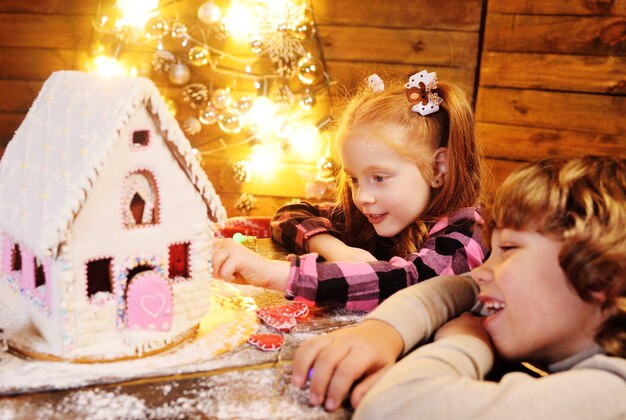 Petits enfants préparant une maison en pain d'épice