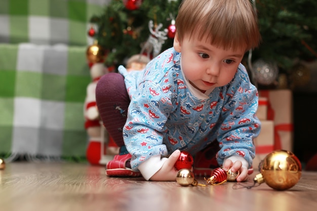 Petits enfants près d'un arbre de Noël avant les vacances