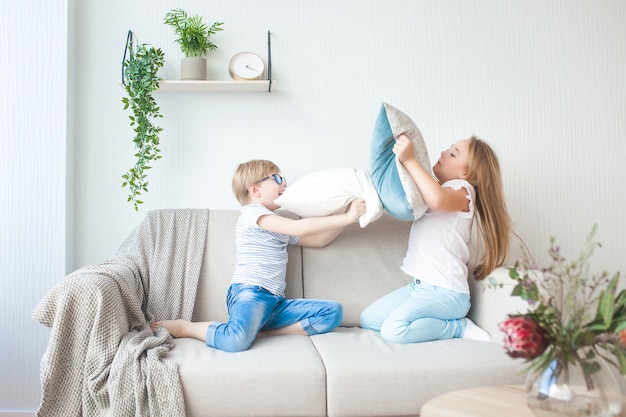 Petits enfants s'amusant à l'intérieur. Bataille d'oreillers