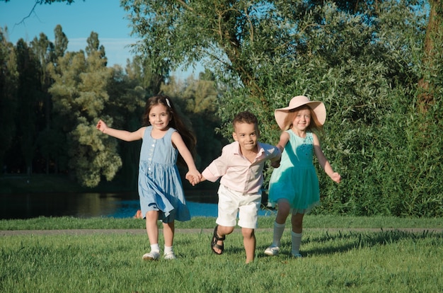 Les petits enfants s'amusent sur la pelouse. deux filles et un garçon