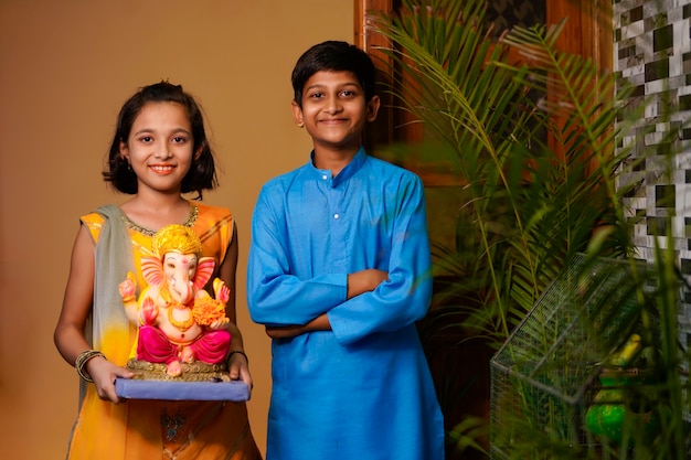 Petits frères et sœurs indiens avec Lord Ganesha.