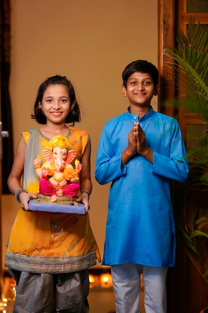 Petits frères et sœurs indiens avec Lord Ganesha.