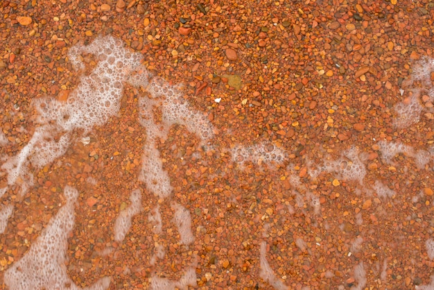 Petits galets de mer rouge fond naturel.