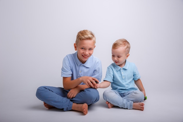 Petits garçons jouant avec des voitures sur un fond blanc