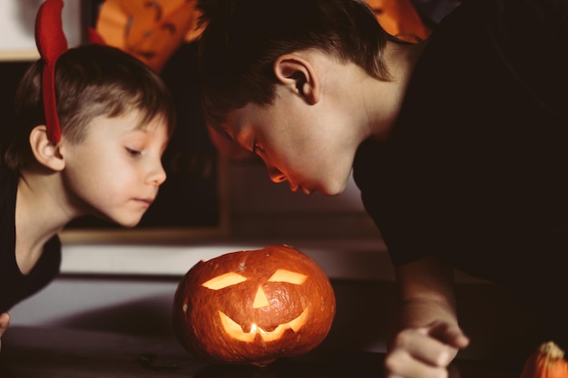 Petits garçons regardant le concept traditionnel d'Halloween de lanterne Jack fait maison