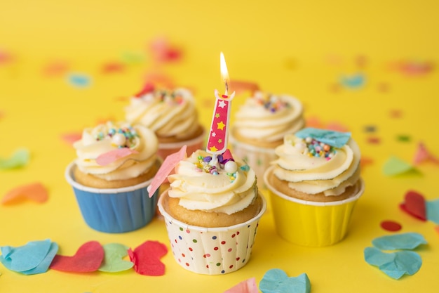 Petits gâteaux d'anniversaire aux couleurs colorées sur fond jaune