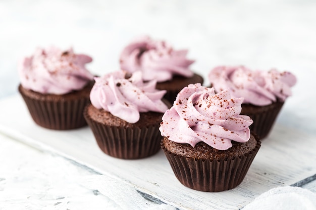 Petits gâteaux au cacao décorés de crème au fromage aux baies et au chocolat