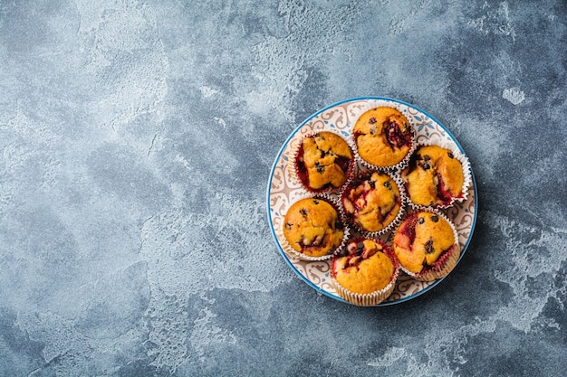 Petits gâteaux au chocolat aux fraises muffins sur vieux support en bois sur une surface gris béton