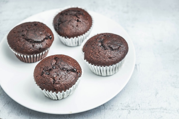 Petits gâteaux au chocolat de boulangerie dans un plat sur blanc