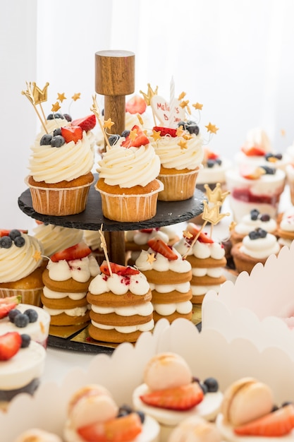 Petits gâteaux au chocolat garnis de mini beignets roses sur une table à dessert