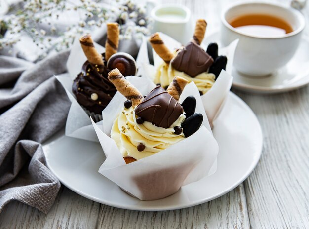 Petits gâteaux au chocolat et tasse de thé sur fond de bois