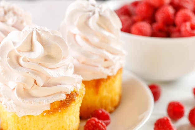 Petits gâteaux aux framboises avec des baies sur fond blanc