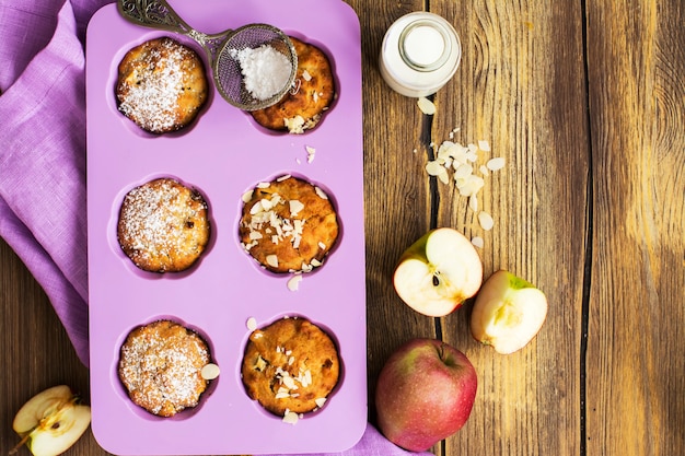 Petits gâteaux aux pommes sur une table en bois