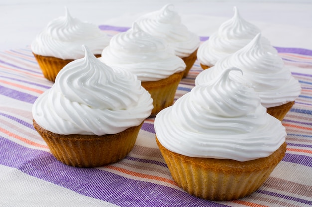 Petits gâteaux blancs sur la serviette en lin à rayures