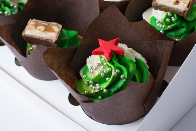 Petits gâteaux à la crème et étoiles rouges sur fond blanc.