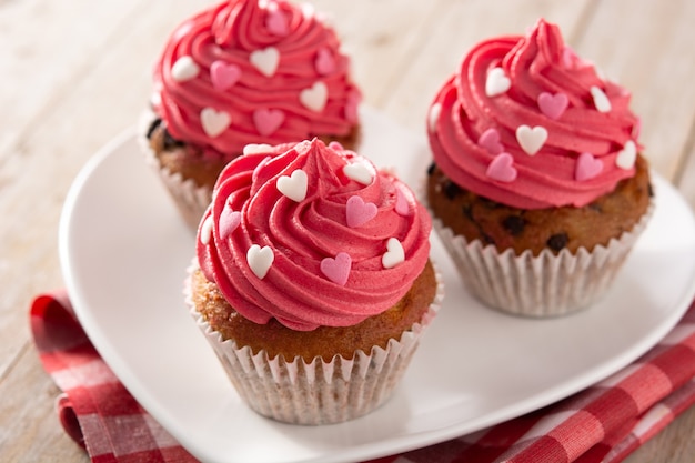 Petits gâteaux décorés de coeurs en sucre pour la Saint-Valentin sur table en bois