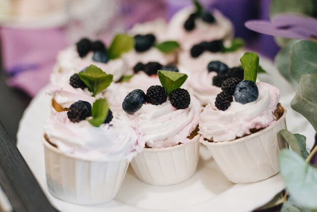 Petits gâteaux faits maison avec des myrtilles et des mûres et de la crème blanche