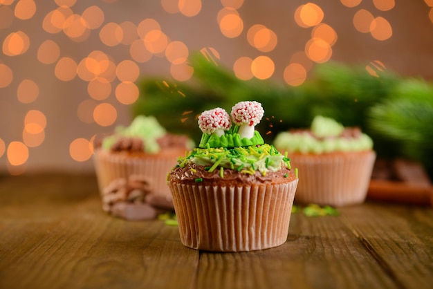 Petits gâteaux savoureux avec crème au beurre, sur table en bois, sur fond clair