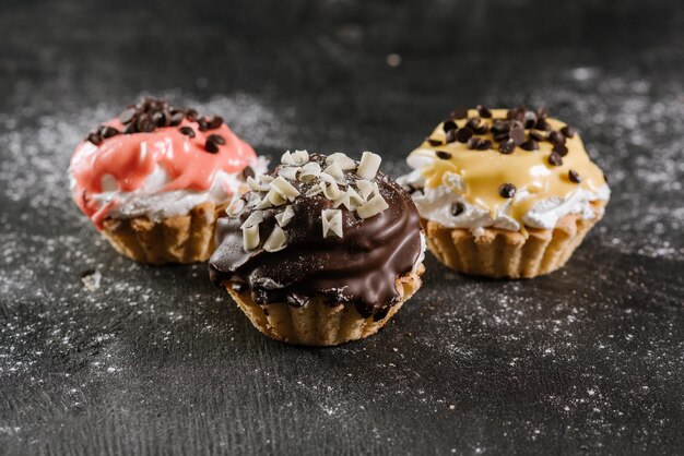 Petits gâteaux sucrés frais sur le fond en bois noir