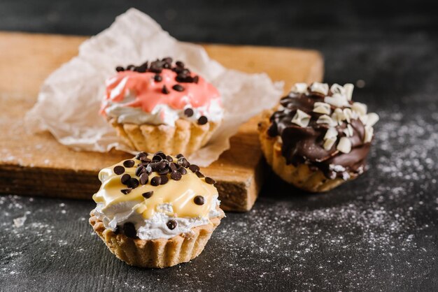 Petits gâteaux sucrés frais sur le fond en bois noir