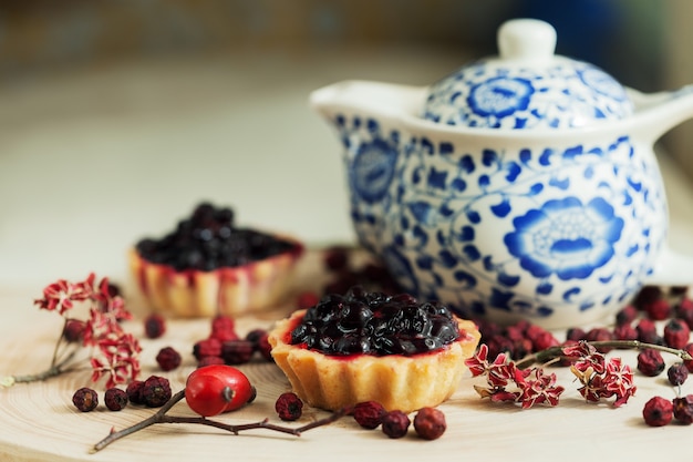 Petits gâteaux sucrés avec des fraises biologiques fraîches sur table en bois