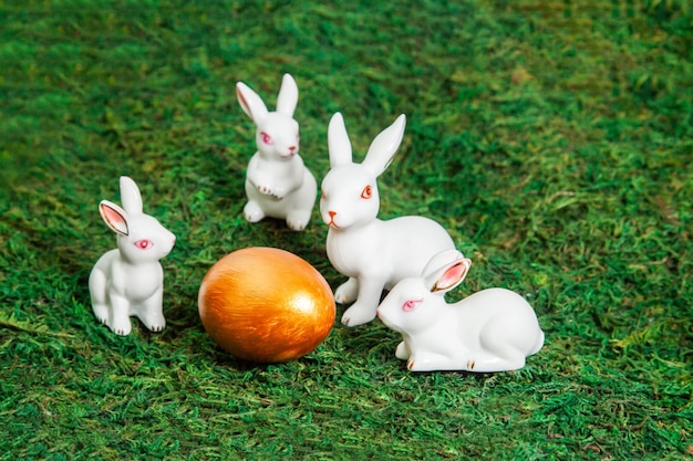 Petits lapins blancs autour de l'oeuf d'or