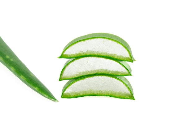 Petits morceaux d'une feuille d'aloe vera formant un tas sur un fond blanc