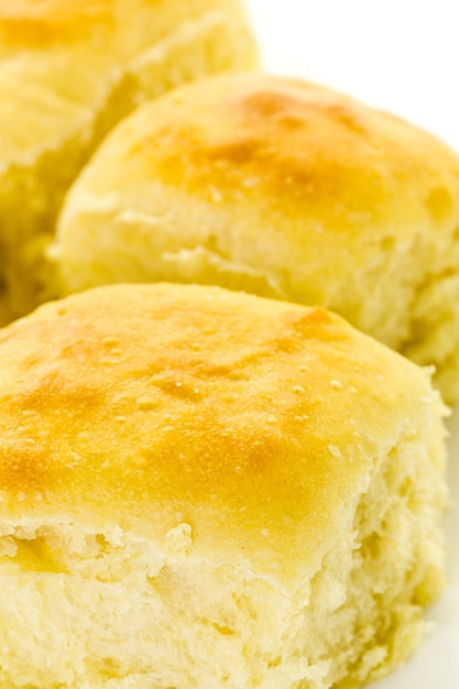 Petits pains au levain fraîchement cuits sur fond blanc.