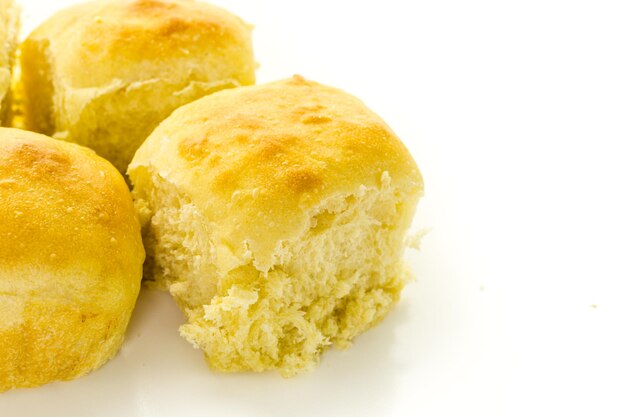 Petits pains au levain fraîchement cuits sur fond blanc.