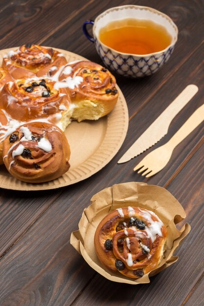 Petits pains aux raisins secs dans une assiette jetable en carton.