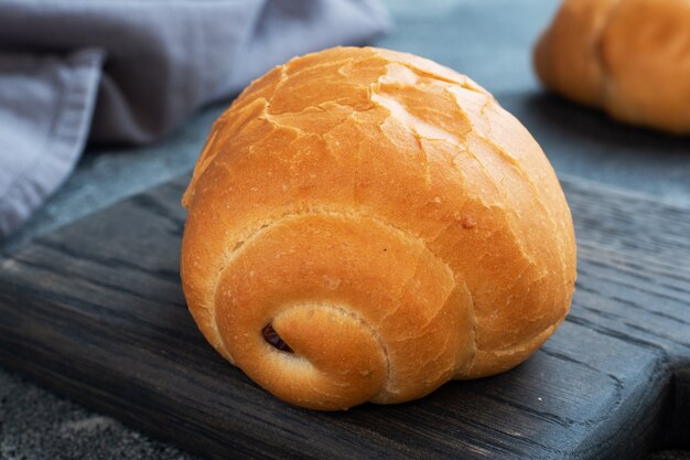 Petits pains de blé frais. Rouleaux pour un hot-dog ou un hamburger. Espace de copie de fond sombre.