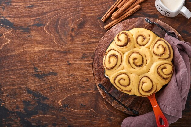 Petits pains à la cannelle ou recette maison au cinabre préparation de pâte crue petits pains à dessert traditionnels sucrés pâtisseries cuits au four tourbillon fait maison mini collation danoise. Ingrédients alimentaires. Vue de dessus. Concept de cuisson d'automne