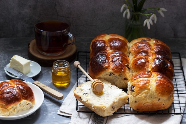 Petits pains chauds traditionnels avec du miel et du beurre sur une surface en béton