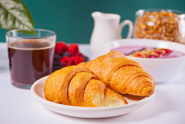 Petits pains croissants frais, baies, confiture de cassis. Concept de petit déjeuner.