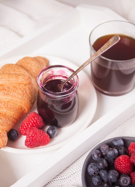 Petits Pains Croissants Frais, Baies, Confiture De Cassis Et Verre De Café. Concept De Petit Déjeuner.