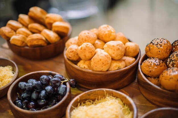 Petits pains faits maison dans une belle tasse en bois Près d'une autre tasse avec des raisins Clouseup