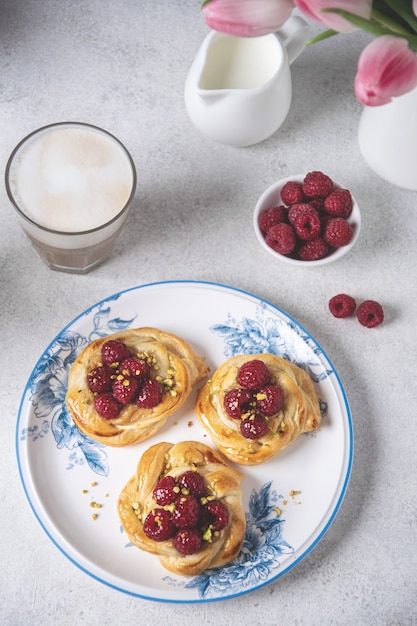 Petits pains frais aux framboises et café cappuccino sur tableau blanc