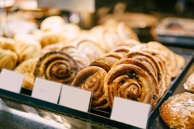 Photo des petits pains ronds avec du glaçage et des raisins secs se trouvent sur une vitrine