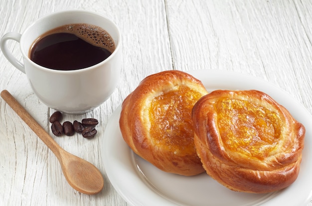 Petits pains sucrés avec confiture et tasse de café chaud