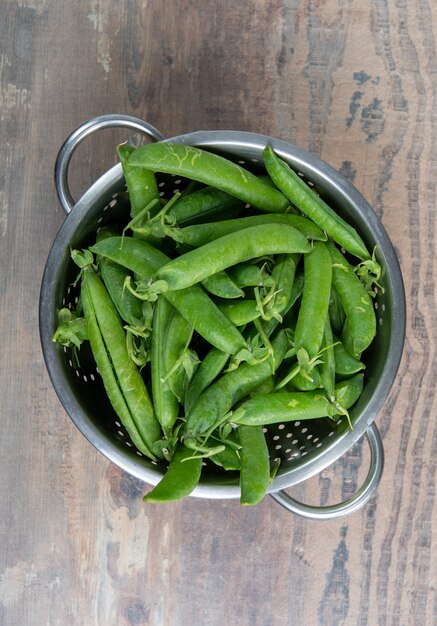 Petits pois frais sur la surface en bois