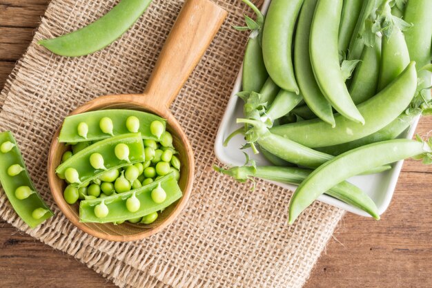 Petits pois verts frais sur le vieux fond en bois, vue de dessus