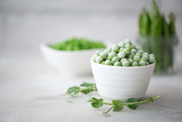 Petits pois verts surgelés et frais dans un bol blanc