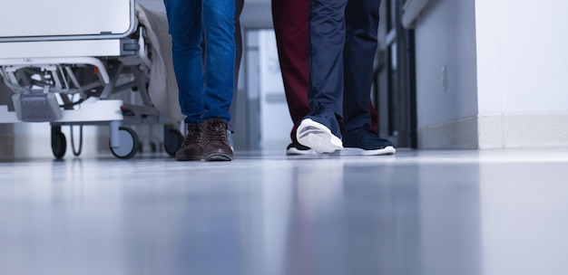 Photo peu de médecins biraciaux marchant dans les couloirs des hôpitaux