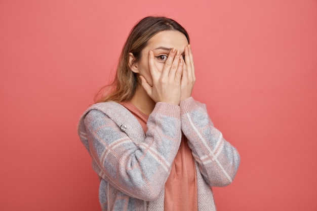 Peur de jeune fille couvrant le visage avec les mains entre les doigts