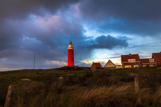 Phare sur le champ contre le ciel