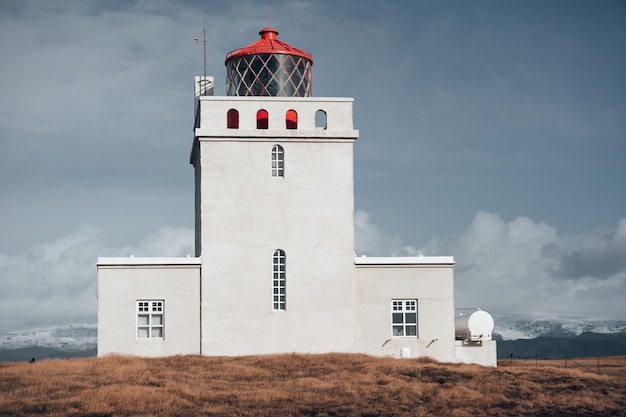 Phare sur le champ contre le ciel
