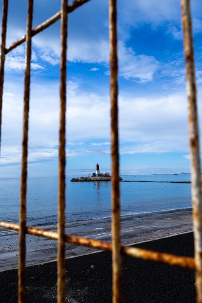 Photo phare dans la mer avec une clôture