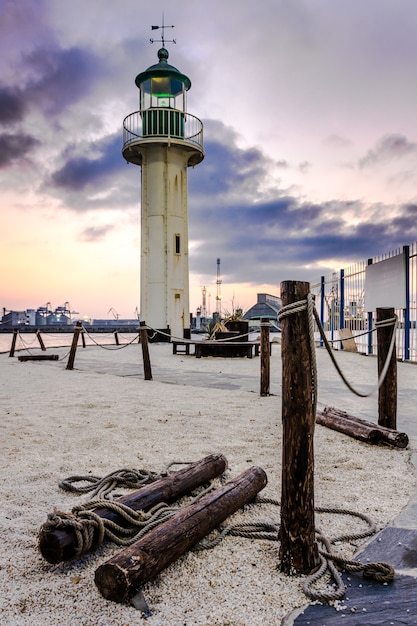 Phare dans le port pendant le coucher de soleil spectaculaire