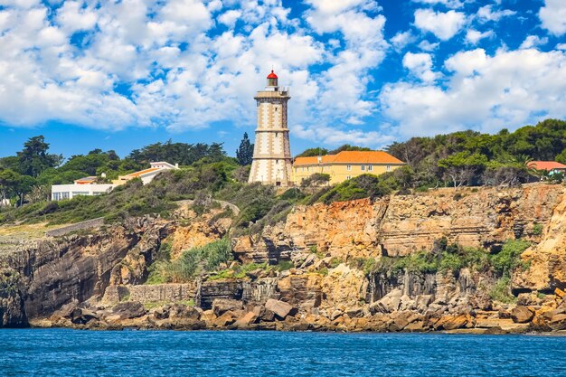 Phare sur une falaise rocheuse et ciel bleu avec des nuages. Lisbonne, Portugal.