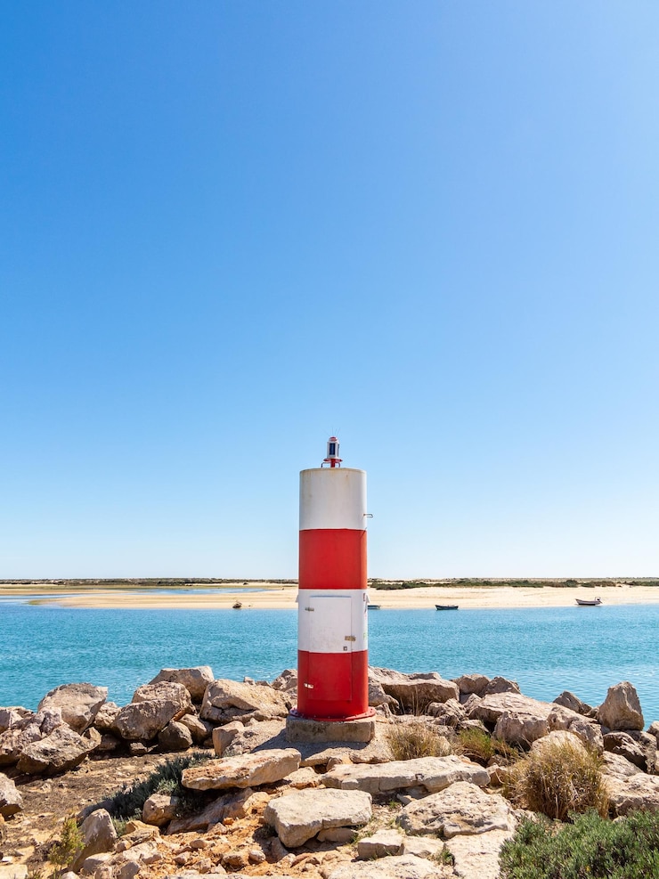 Photo phare par la mer contre un ciel bleu clair